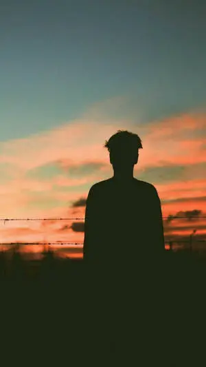 ظل صبي يشاهد غروب الشمس