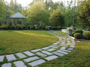 a garden path with a gazebo and a pond