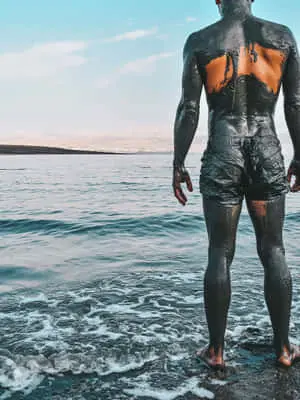 رجل مغطى بطين البحر الميت