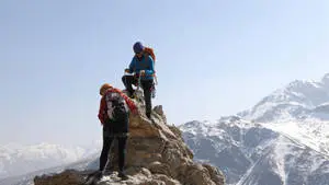 Mountaineers Climbing To Mountain Peak