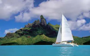 A graceful white sailboat gliding across a crystal-blue lake