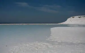 A picturesque river flowing through snow-covered shores